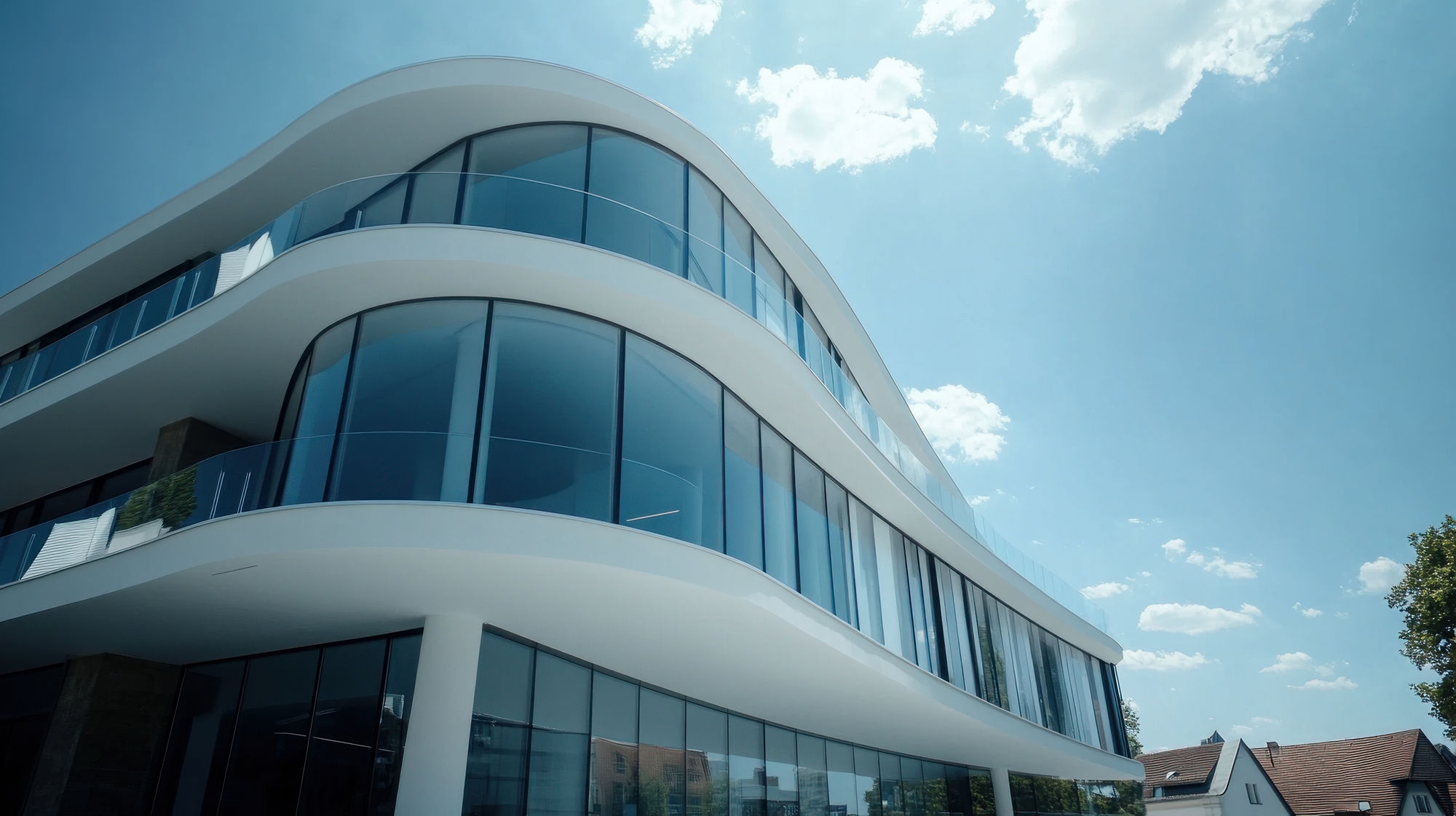 Modern, curved office building with large windows under a clear sky