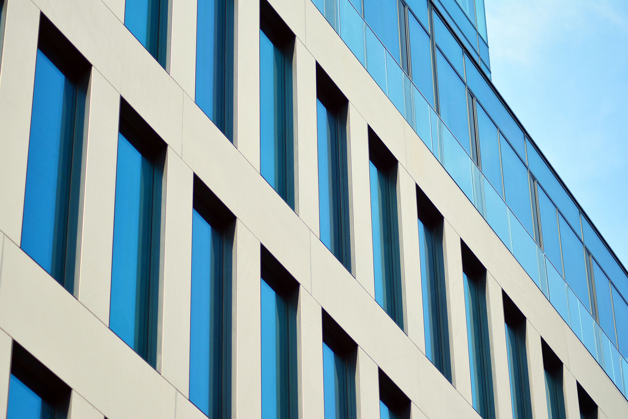 Abstract fragment of contemporary architecture, walls made of glass and concrete. Glass curtain wall of modern office building