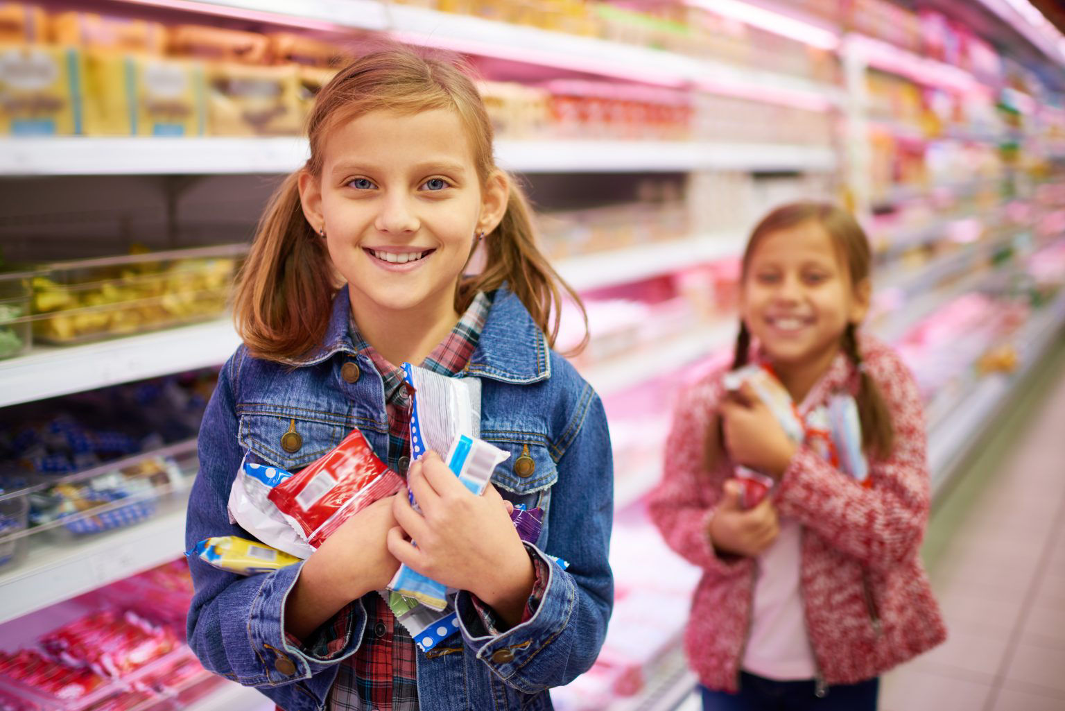 Kinder halten lächelnd Plastikbehälter in einem Supermarkt