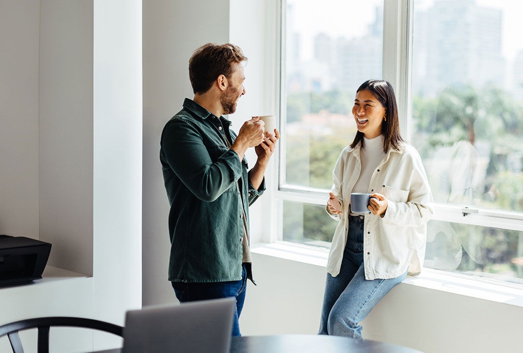 Two people are having a conversation over coffee.
