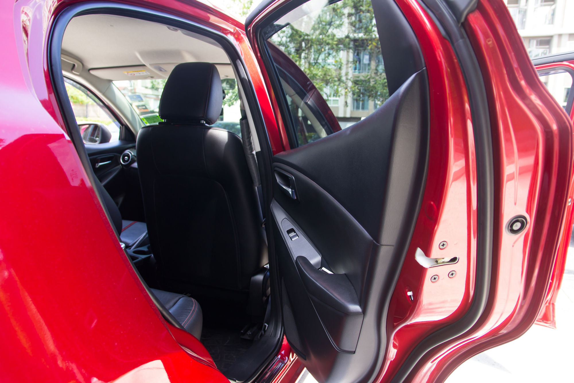 Die geöffnete hintere Tür eines Autos. Der Blick fällt ins Auto, zu sehen ist der Beifahrersitz von hinten.