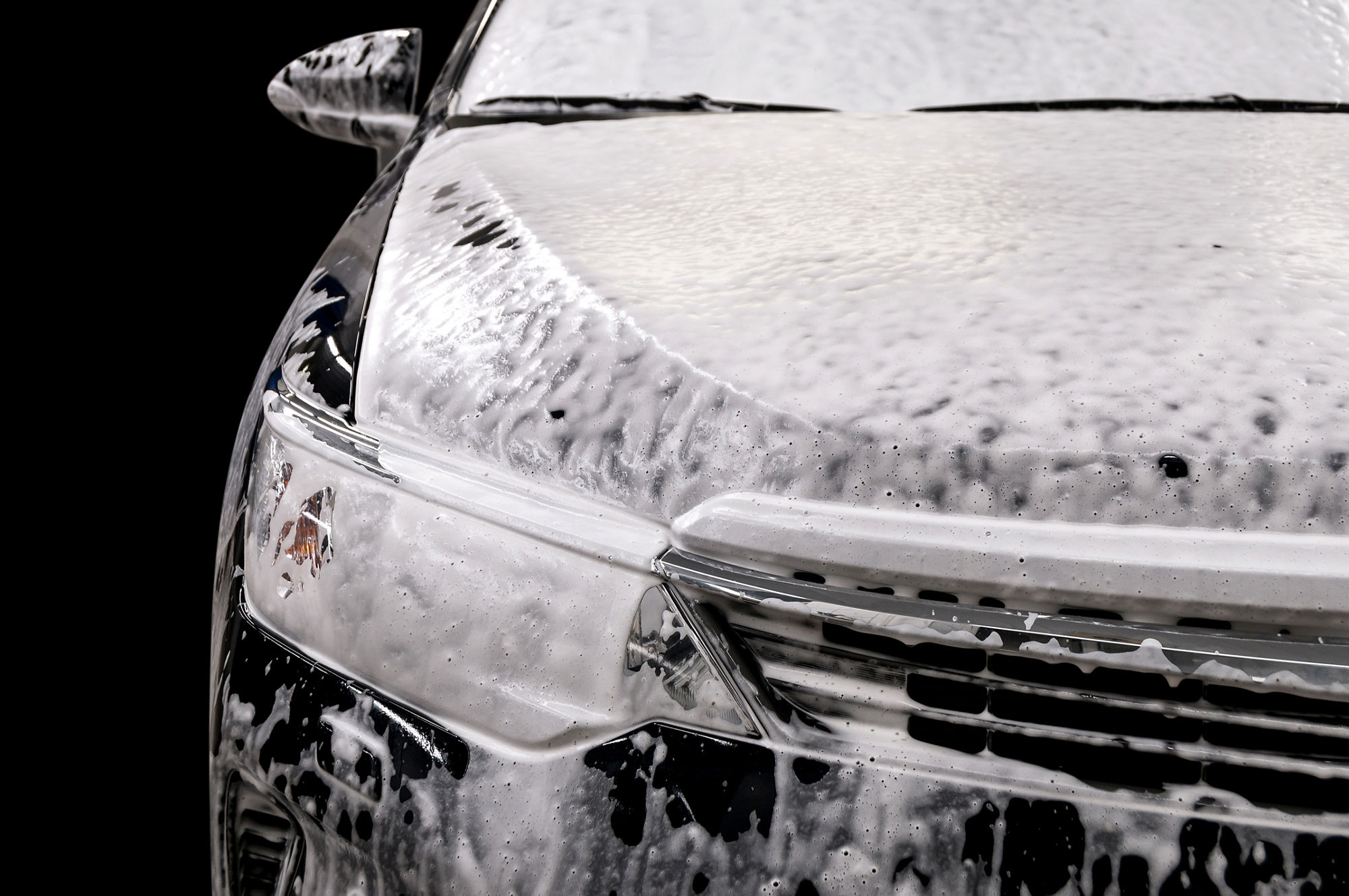 Car wash with soap. Modern auto covered by foam.