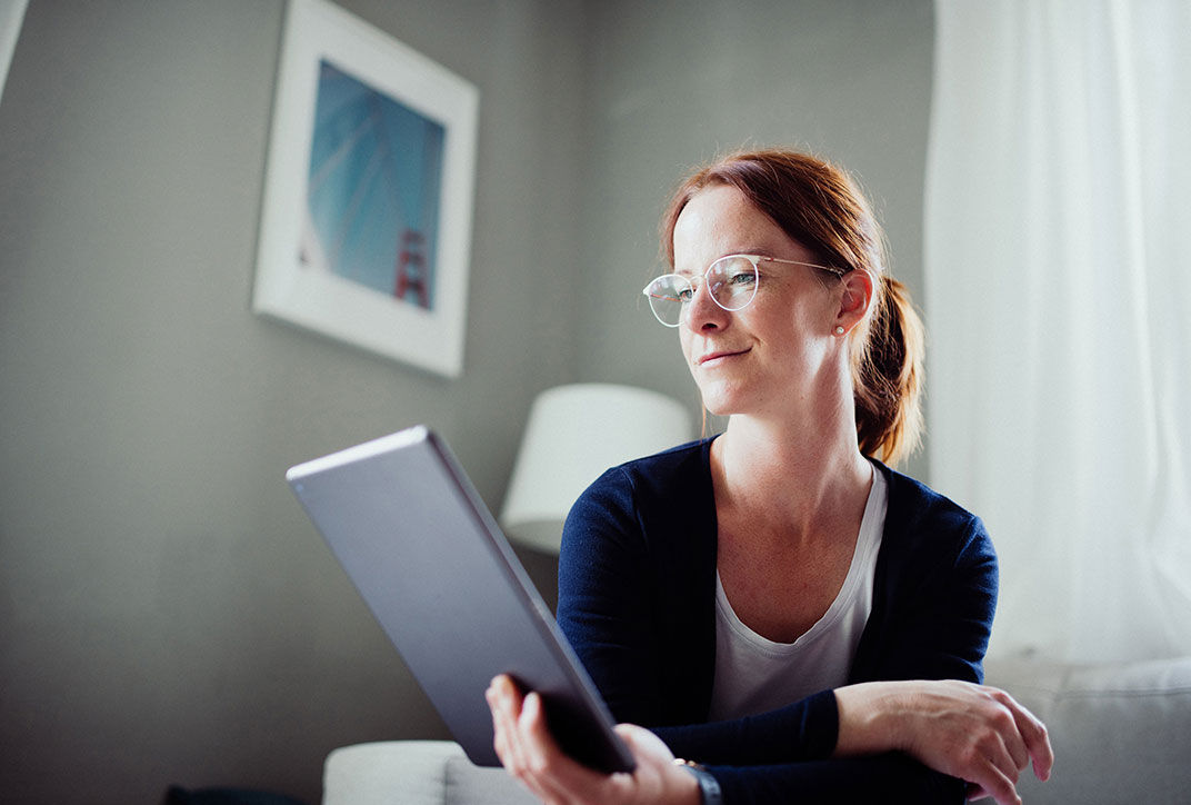 The female job applicant is looking at documents on a tablet.