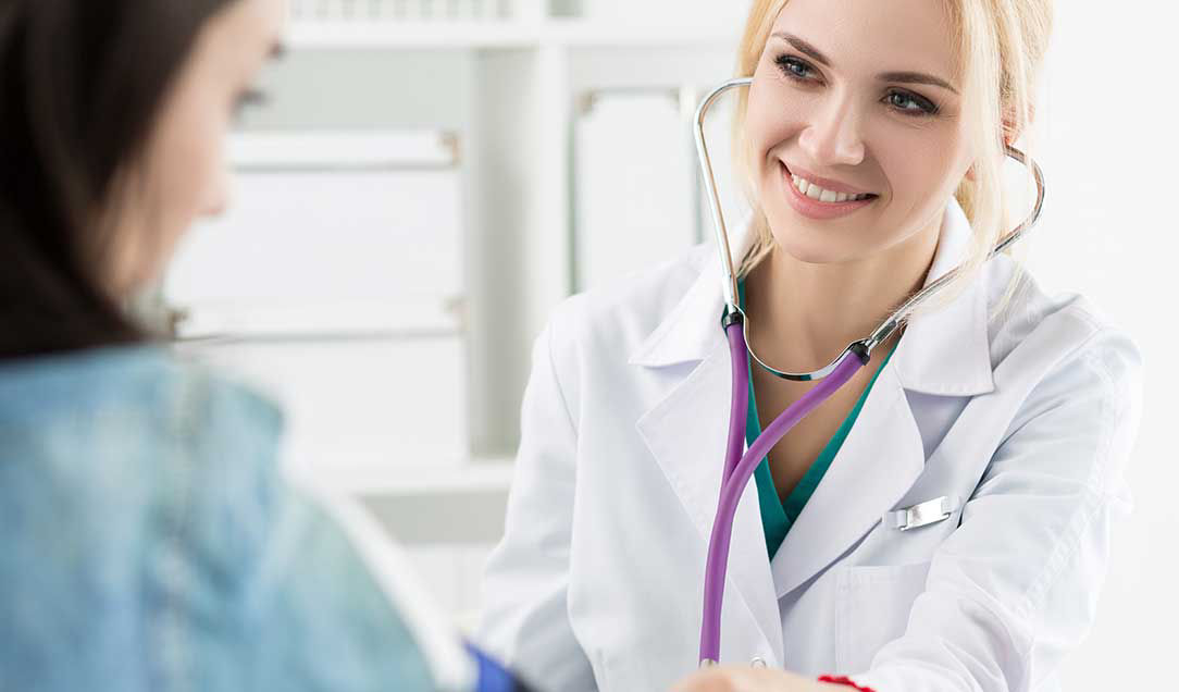 A physician in a white coat measuring a patient‘s blood pressure.