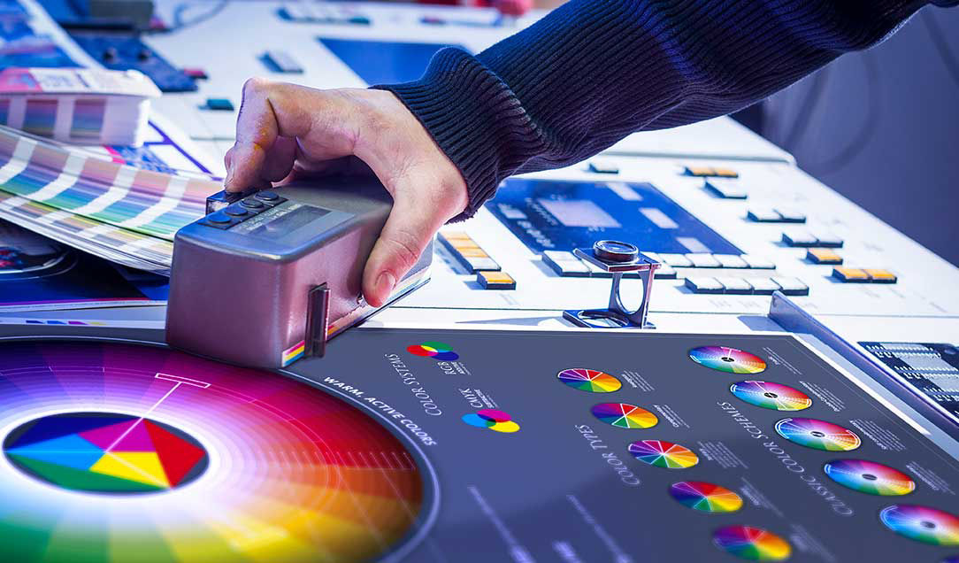 A person moving a color recognition device over a color scale.