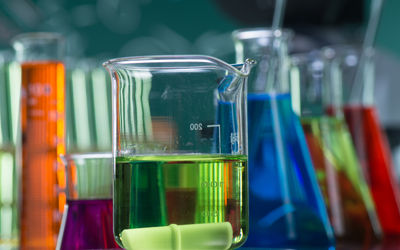 Verschiedene Laborgläser aus dem Chemielabor mit verschiedenfarbigen Flüssigkeiten.
