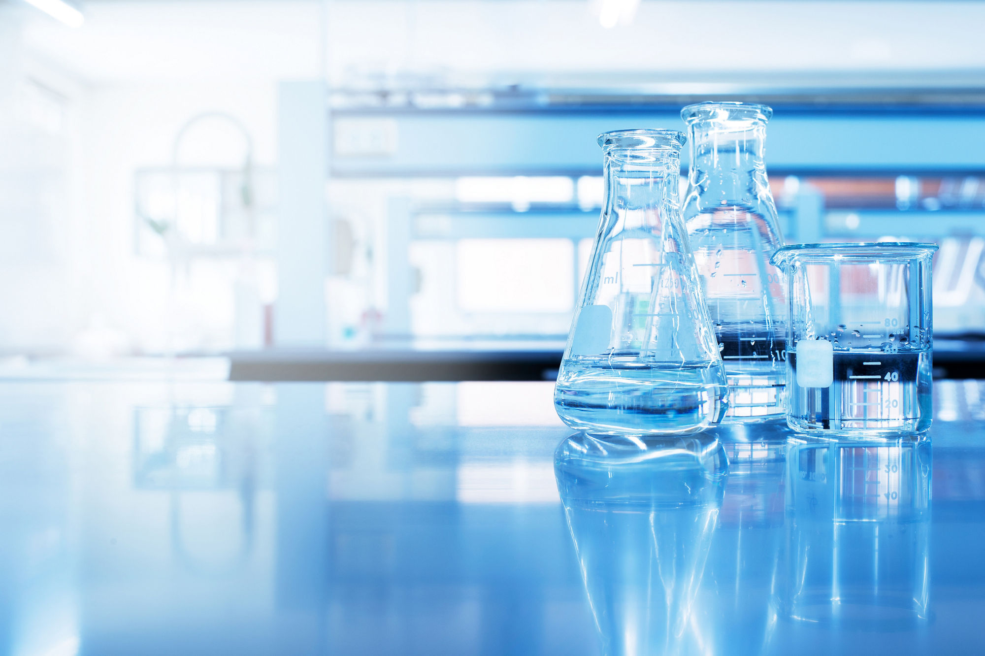 clear water in beaker and flask glass in chemistry blue science laboratory background