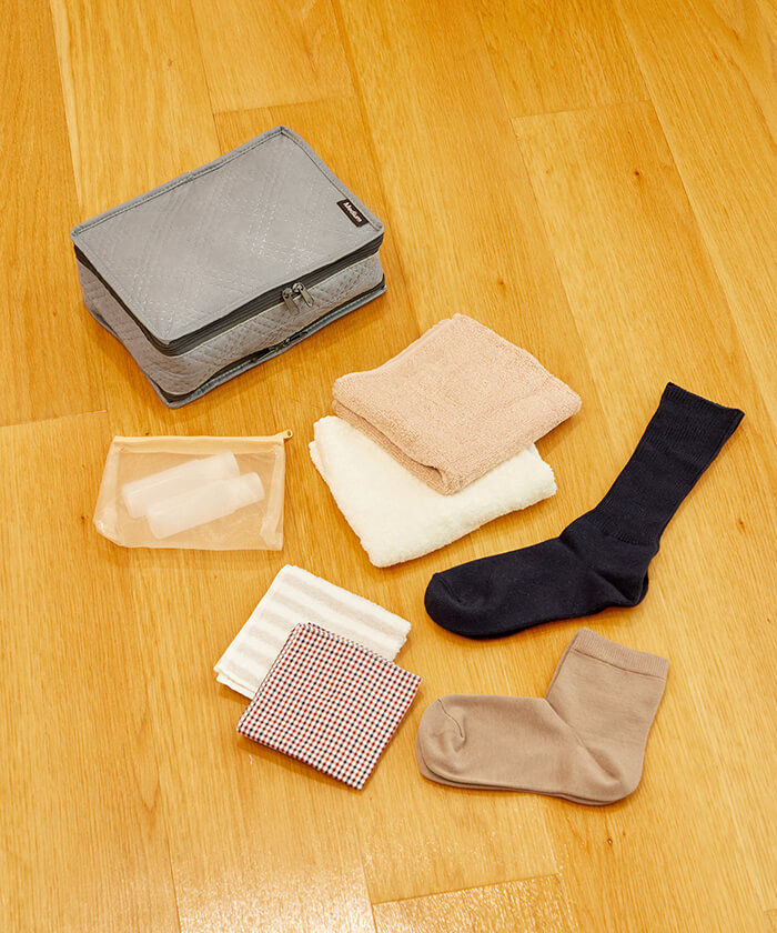 Deodorizing travel pouch with compartments; Example of M size storage: 2 face towels, 2 handkerchiefs, 2 pairs of socks, 1 set of makeup pouches
