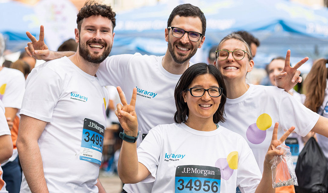 Group of cheerful runners wearing white Kuraray T-shirts at the J.P. Morgan run.