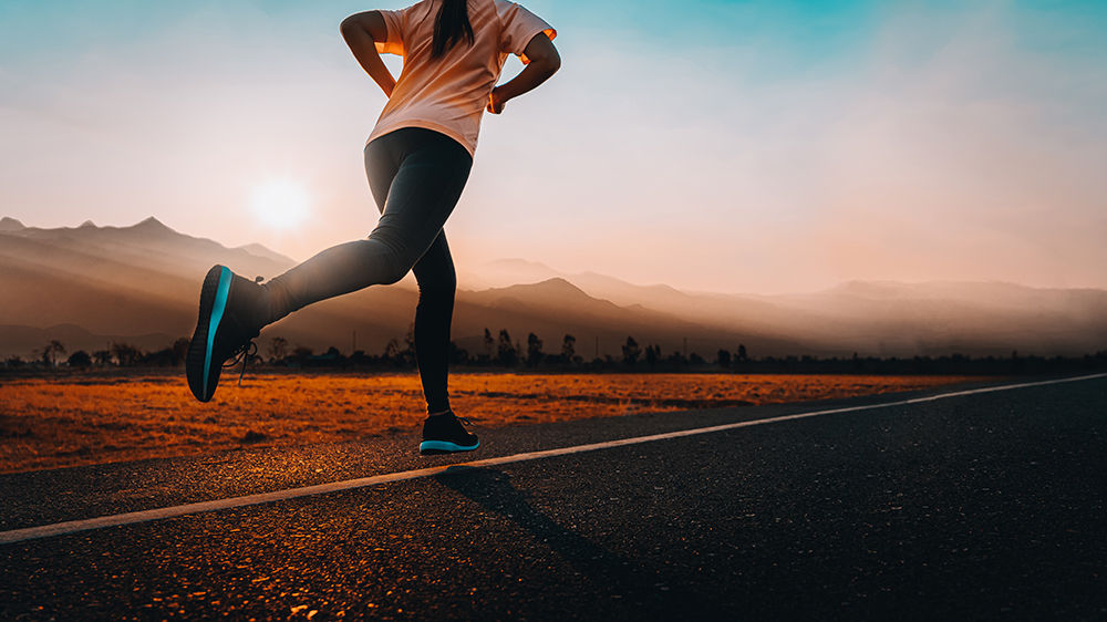 Young asian woman enjoys running outside with beautiful summer evening in the countryside.